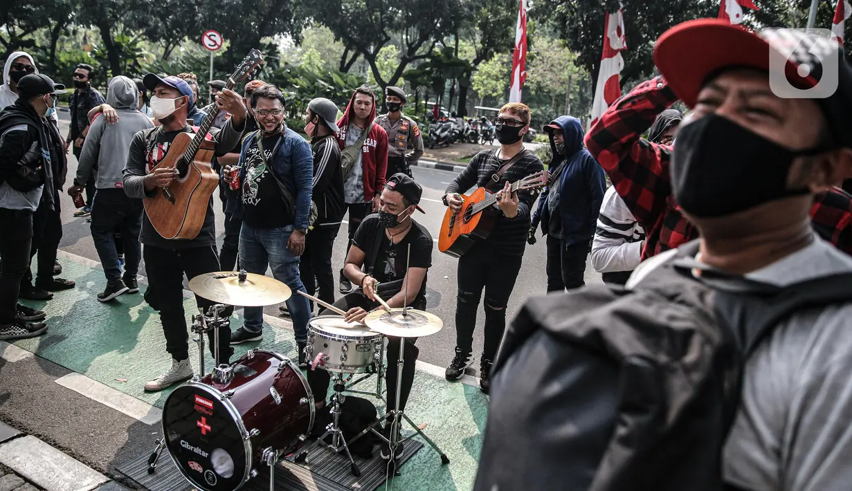 Sejumlah musisi kafe saat melaksanakan aksi di depan Balai Kota Jakarta, Rabu (8/7/2020). Aksi ngamen di depan Balai Kota Jakarta yang diikuti oleh musisi kafe itu untuk menyuarakan aspirasi pekerja seni harian yang terdampak mata pencahariannya selama masa PSBB. (Liputan6.com/Faizal Fanani)