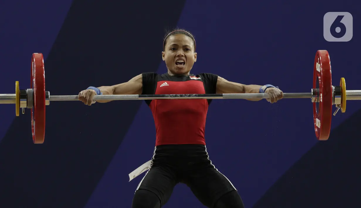 Lifter putri Indonesia, Lisa Setiawati melakukan angkatan pada SEA Games 2019 cabang angkat besi nomor 45 kg di Stadion Rizal Memorial, Manila, Minggu (1/12/2019). Dirinya meraih perak dengan total angkatan 169 kg. (Bola.com/M Iqbal Ichsan)