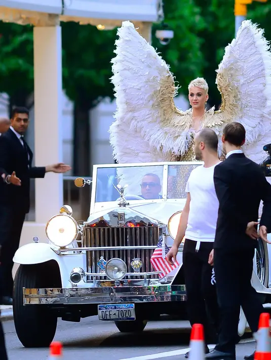 Outfit Katy Perry yang membutuhkan mobil dengan atap terbuka untuk menghadiri Met Gala 2018. Katy Perry mengenakan kostum dari Versace, lengkap dengan sayap malaikatnya, yang membutuhkan mobil atap terbuka untuk mengantarkannya hingga ke venue. Foto: Vogue.
