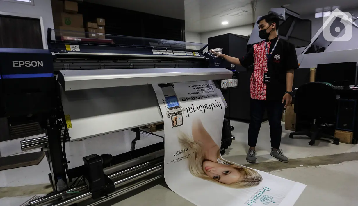 Pekerja mencetak di mesin cetak digital printing PT Bintang Sempurna di kawasan Benhil, Jakarta Pusat, Rabu (24/2/2021). Setidaknya omset yang dihasilkan digital printing ini tidak sebesar seblum pandemi berlangsung. (Liputan6.com/Johan Tallo)