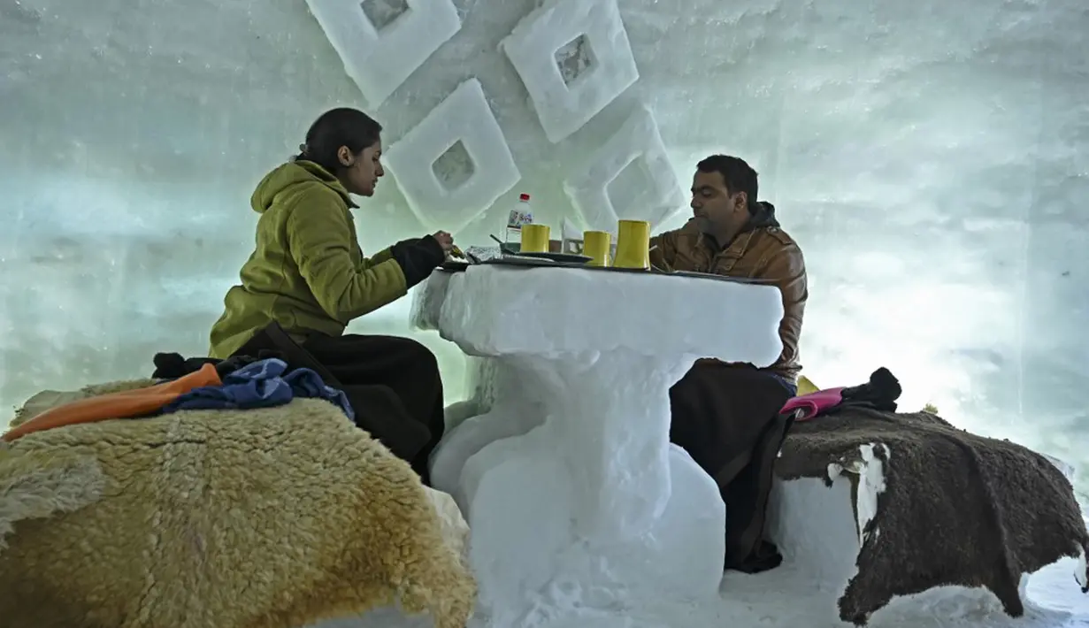 Para tamu terlihat dalam Igloo yang terbuat dari salju di resor ski di Gulmarg, sekitar 55 km utara Srinagar, Jammu dan Kashmir, India, 25 Januari 2021. Meski terdengar begitu asing, Gulmarg termasuk salah satu dari tujuh destinasi permainan salju terbaik di dunia. (Tauseef MUSTAFA/AFP)