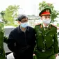 Mantan menteri kesehatan Vietnam Nguyen Thanh Long (tengah) divonis penjara karena korupsi atas suap produksi alat tes COVID-19 di Hanoi. Daam foto saat sidang pada 3 Januari 2024. (AFP)