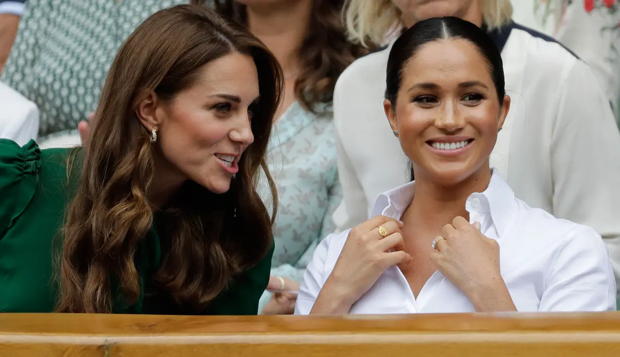 Duchess of Cambridge Kate Middleton (kiri) dan Duchess of Sussex Meghan Markle berbincang saat menyaksikan pertandingan final tunggal putri Wimbledon 2019 antara Serena Williams dengan Simona Halep di All England Lawn Tennis and Croquet Club, London, Inggris, Sabtu (13/7/2019). (BEN CURTIS/POOL/AFP)