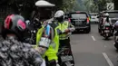 Polisi lalu lintas memeriksa kelengkapan surat pengendara saat razia Operasi Patuh Jaya 2019 di kawasan Kemanggisan, Jakarta, Kamis (29/8/2019). Operasi ini diharapkan dapat meningkatkan kepatuhan dan ketertiban dalam berlalu lintas serta mengurangi angka kecelakaan. (Liputan6.com/Faizal Fanani)