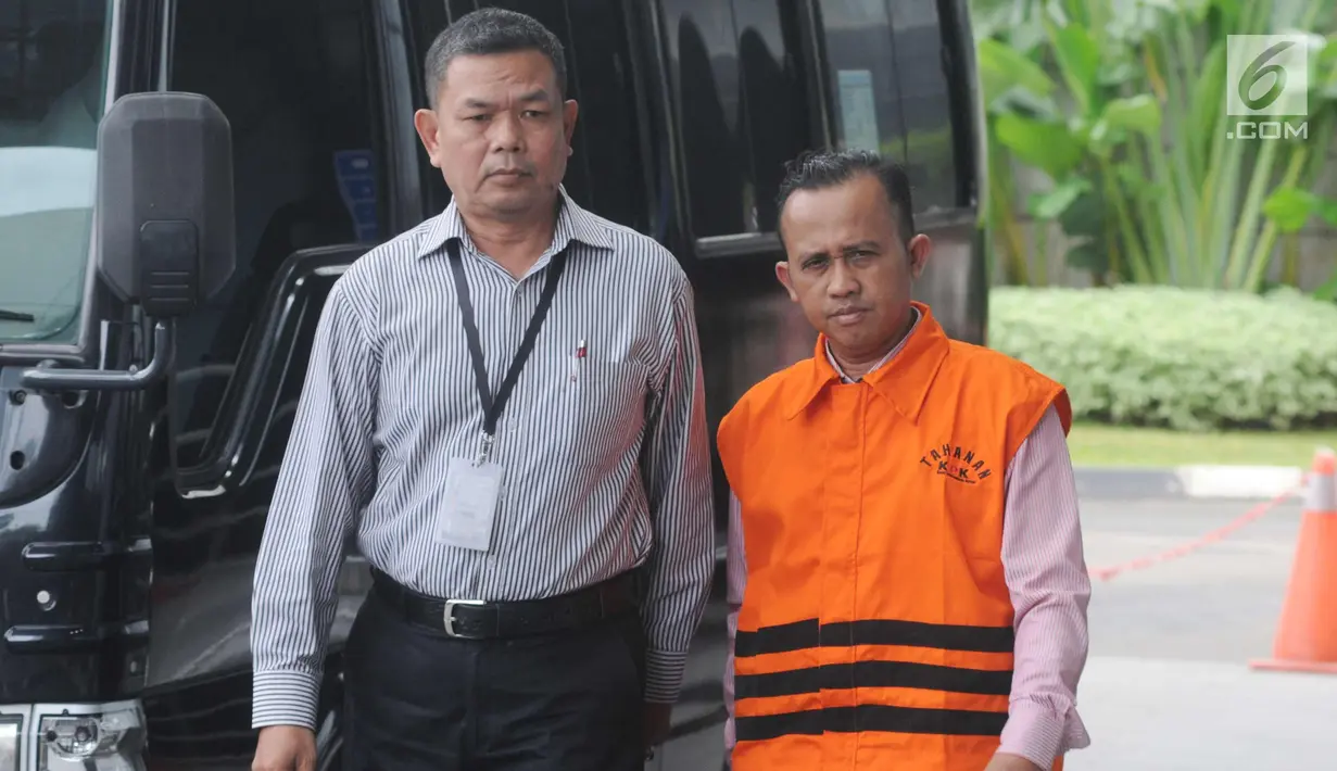 Pengacara Agus Wiratno dikawal petugas saat tiba untuk menjalani pemeriksaan perdana pasca terjaring OTT di gedung KPK, Jakarta, Rabu (21/3). Agus diduga melakukan suap terhadap ketua majelis hakim Wahyu Widya Nurfitri. (Merdeka.com/Dwi Narwoko)