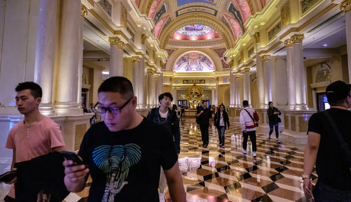 Wisatawan berjalan dalam resor kasino The Venetian di Macau, 5 Maret 2019. Sekitar 20 persen orang yang tinggal di Macau bekerja di kasino. (Anthony Wallace/AFP)
