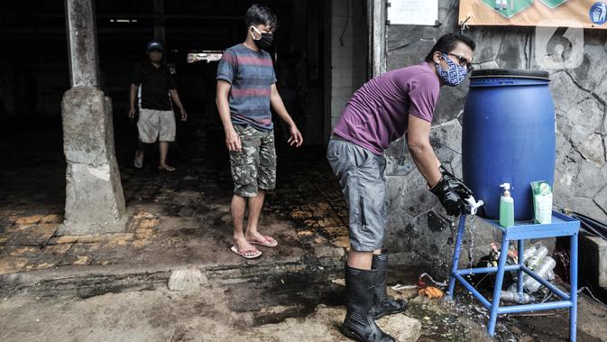 Petugas mencuci tangan saat keluar masuk area penyembelihan hewan kurban Idul Adha di RPH Pulogadung, Jakarta, Jumat (31/7/2020). RPH Pulogadung menyembelih 50 sapi dan puluhan kambing dengan proses pemotongan sesuai syariat Islam dan protokol kesehatan COVID-19. (merdeka.com/Iqbal S. Nugroho)