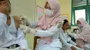 Ekspresi siswa MIN Ulee Kareng saat mendapat vaksinasi anti virus difteri di Banda Aceh, Aceh, Selasa (20/2). Dari catatan Dinkes, difteri kerap menyerang manusia kisaran usia 4 - 28 tahun. (CHAIDEER MAHYUDDIN/AFP)