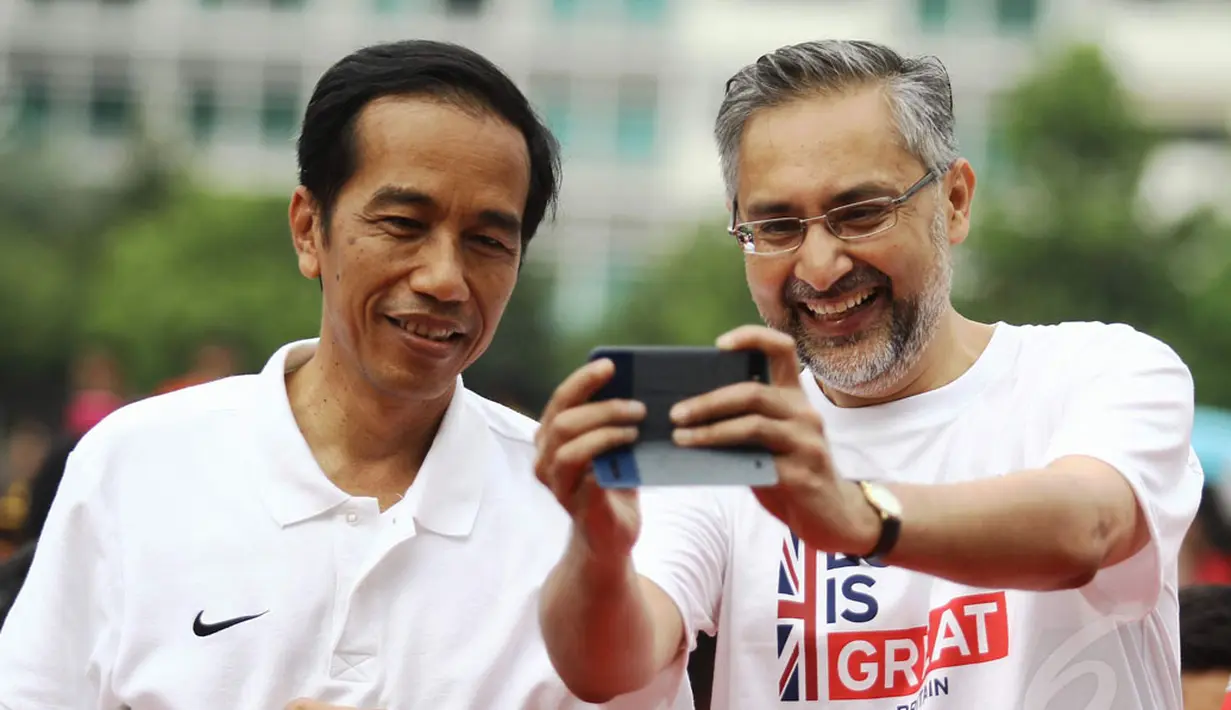 Dubes Inggris untuk Indonesia, Moazzam Malik (kanan) berfoto bersama Presiden Joko Widodo di kawasan Bundaran HI Jakarta, Minggu (30/11/2014). (Liputan6.com/Faizal Fanani)