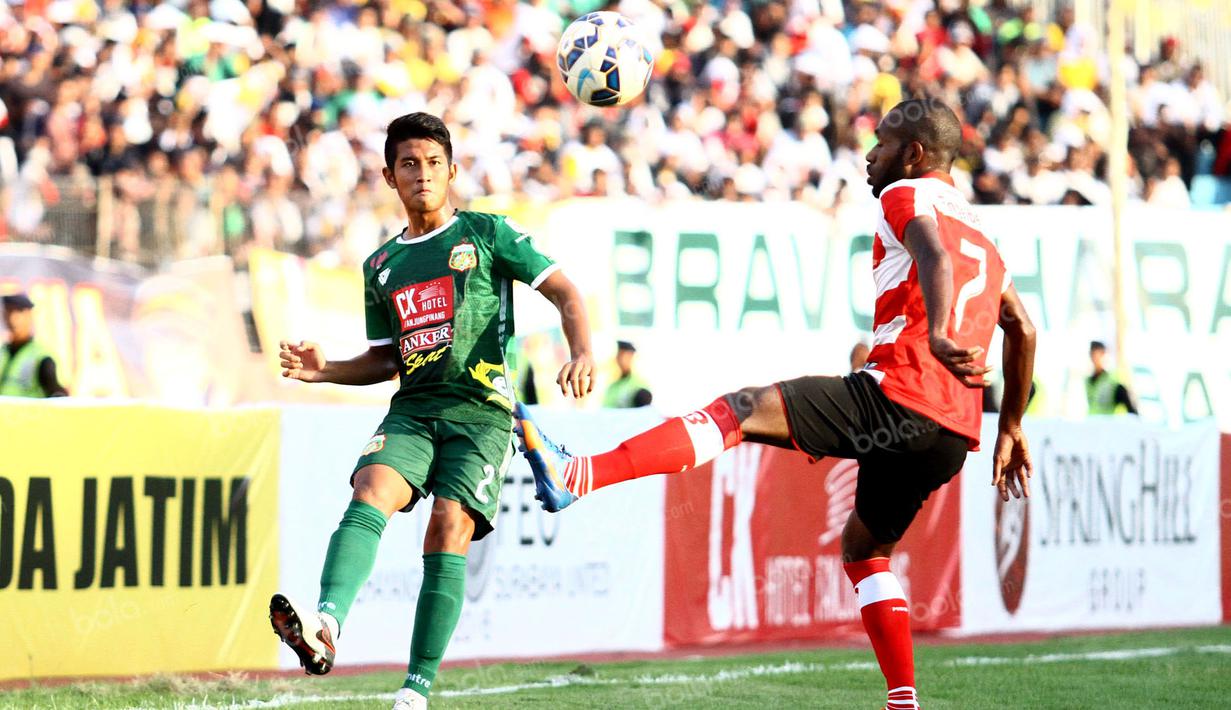 Pemain Bhayangkara Surabaya United, Putu Gede, berusaha melewati hadangan pemain Madura United dalam laga Trofeo Kapolda Jatim di Stadion Gelora Delta, Sidoarjo, Minggu (24/4/2016). (Bola.com/Zulfirdaus Harahap)