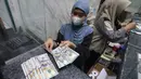 Kebijakan ini merupakan bagian dari tujuh langkah strategis BI untuk memperkuat ekonomi nasional. Tampak dalam foto, karyawan menunjukkan uang pecahan dolar Amerika Serikat (AS) di salah satu gerai penukaran mata uang asing, Jakarta, Rabu (5/5/2026). (Kapanlagi.com/Budy Santoso)