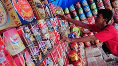Seorang pedagang merapikan kue kering Lebaran di Jl Raya Bogor Km 26, Jakarta, Minggu (20/7/14). (Liputan6.com/Faizal Fanani)