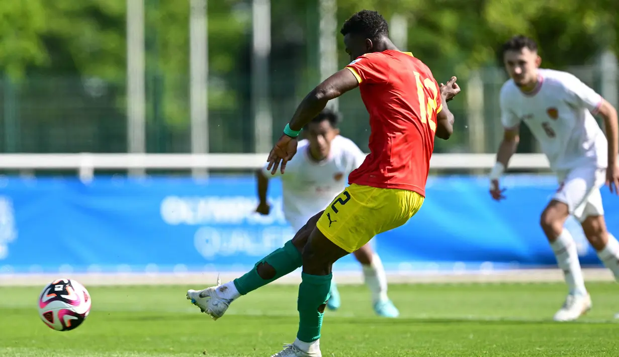 Striker Guinea U-23, Algassime Bah mengeksekusi tendangan penalti ke gawang Timnas Indonesia U-23 pada laga play-off antar-konfederasi menuju Olimpiade Paris 2024 di Stade Pierre Pibarot, Centre National du Football de Clairefontaine, Prancis, Kamis (9/5/2024). (AFP/Miguel Medina)
