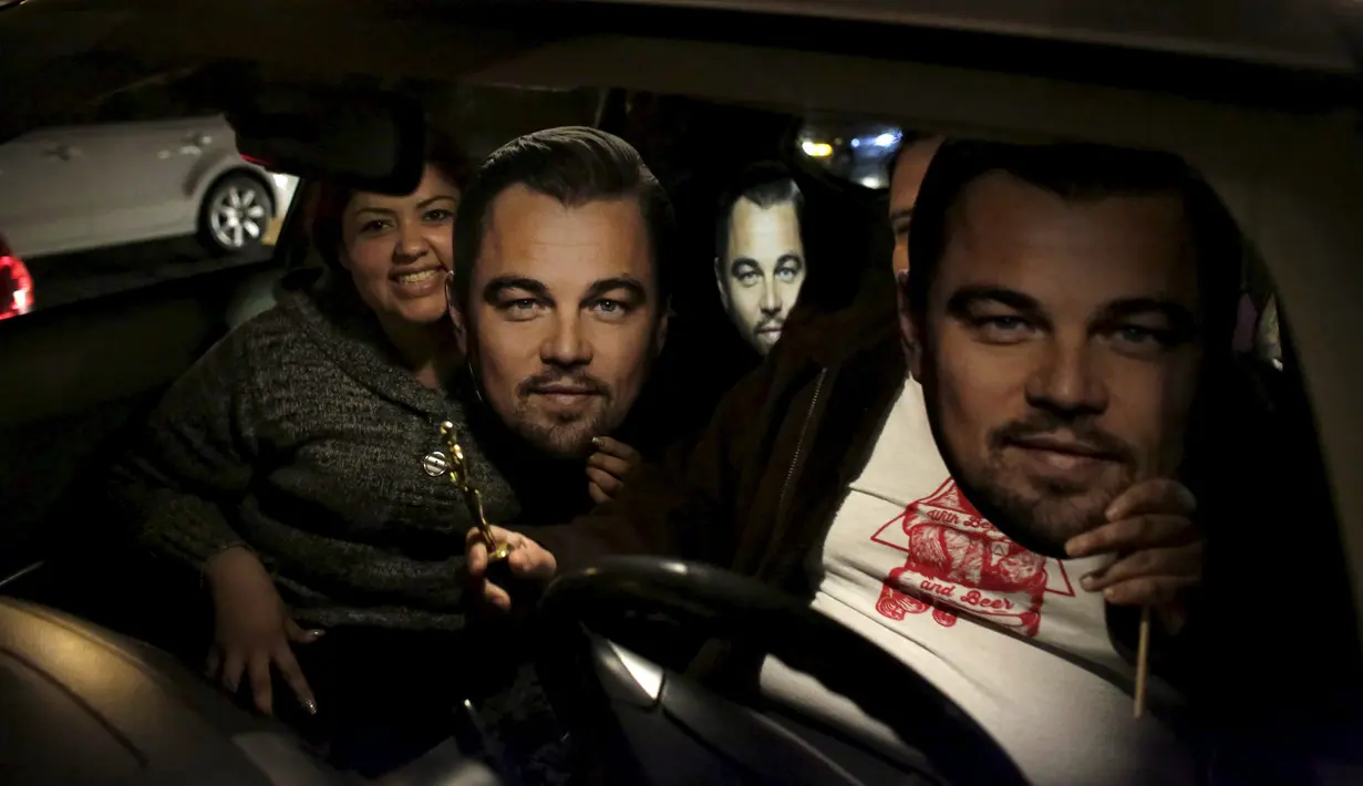 Dua fans menunjukkan topeng Leonardo DiCaprio saat mereka merayakan kemenangan sang idola sebagai Aktor Terbaik untuk film The Revenant pada Academy Awards ke-88 atau lebih dikenal Piala Oscar 2016, di Monterrey, Senin (29/2). (REUTERS/Daniel Becerril)