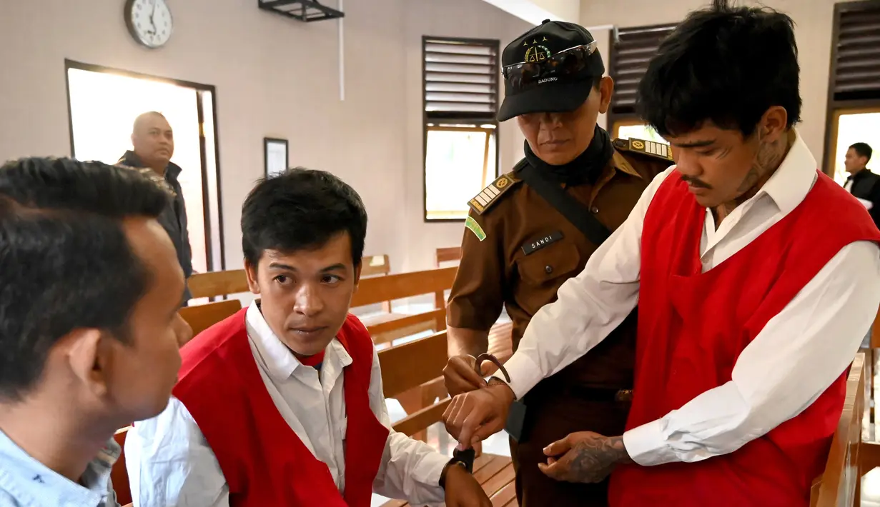 Warga negara Thailand, Prakob Seetasang dan Adison Phonlamat bersiap menjalani persidangan kasus penyelundupan narkoba di pengadilan Denpasar, Bali (23/9/2019). Keduanya diduga berusaha menyelundupkan 1 kg metamfetamin ke Bali. (AFP Photo/Sonny Tumbelaka)