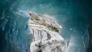 Wisatawan mendaki tangga saat mengunjungi sebuah gua es, "La Grotte de Glace", di gletser Mer de Glace (Lautan Es) di Chamonix-Mont-Blanc, Pegunungan Alpen Prancis, Jumat (19/7/2019). Gua yang berada di lereng Mont Blanc ini memiliki panjang 7 km dengan kedalaman 200 meter. (PHILIPPE DESMAZES/AFP)