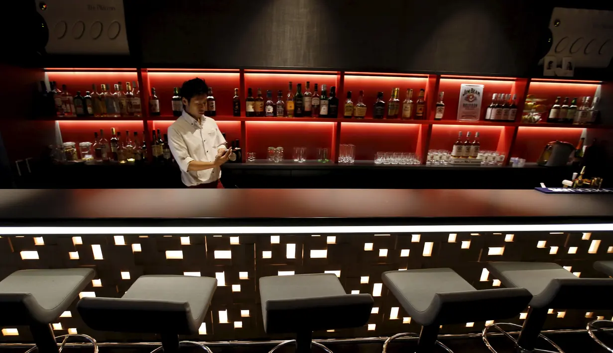 Seorang pelayan saat berjaga di sebuah bar di First Hotel Cabin, Tokyo, Jepang (30/7/2015). Layanan kelas bisnis di Hotel First Cabin menawarkan interior yang unik dan nyaman. (Reuters/Toru Hanai)