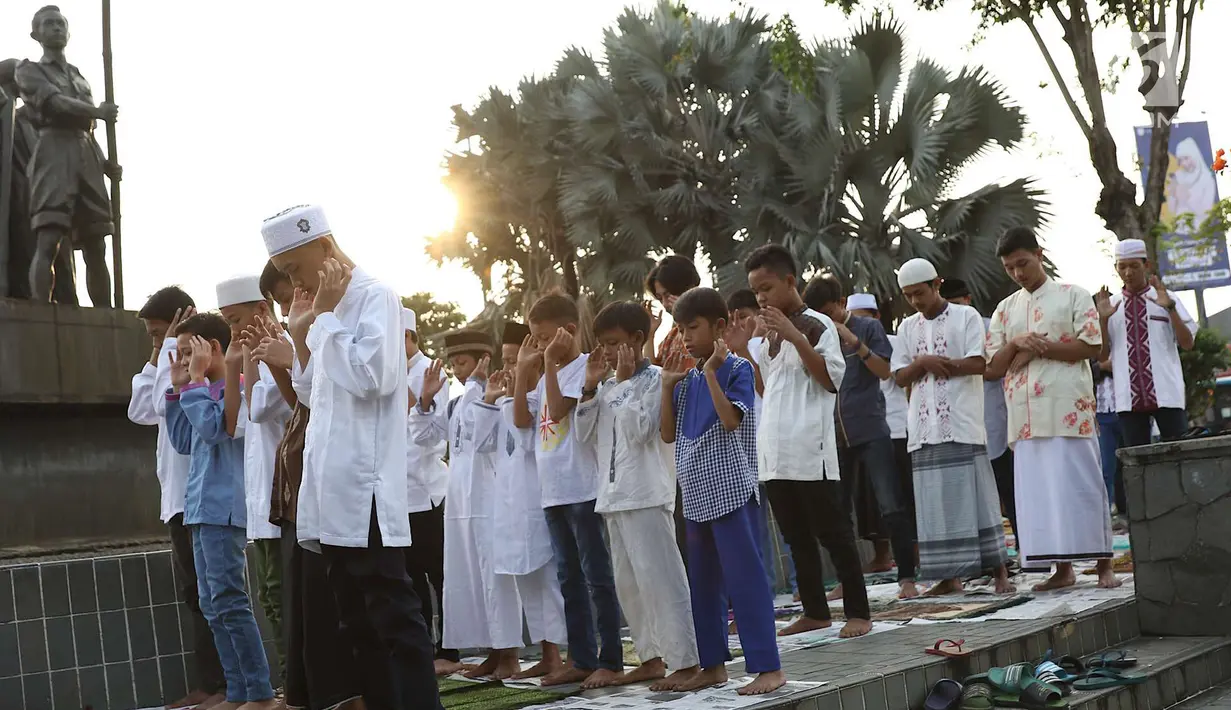 Umat muslim salat id Hari Raya Idul Fitri 1 Syawal 1439 H di kawasan Senen, Jakarta, Jumat (15/6). Setiap tahun, umat muslim antusias melaksanakan salat id dengan memadati jalan-jalan di sekitar stasiun dan pasar tersebut. (Liputan6.com/Immanuel Antonius)