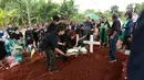 Pihak keluarga melakukan tabur bunga dalam prosesi pemakaman mantan pelatih Timnas Indonesia, Benny Dolo di Tempat Pemakaman Umum (TPU) Pondok Benda, Pamulang, Tangerang Selatan, Sabtu (4/2/2023) siang WIB. Bendol, sapaan akrabnya, meninggal dunia pada Rabu (1/2/2023) karena sakit. (Bola.com/M Iqbal Ichsan)