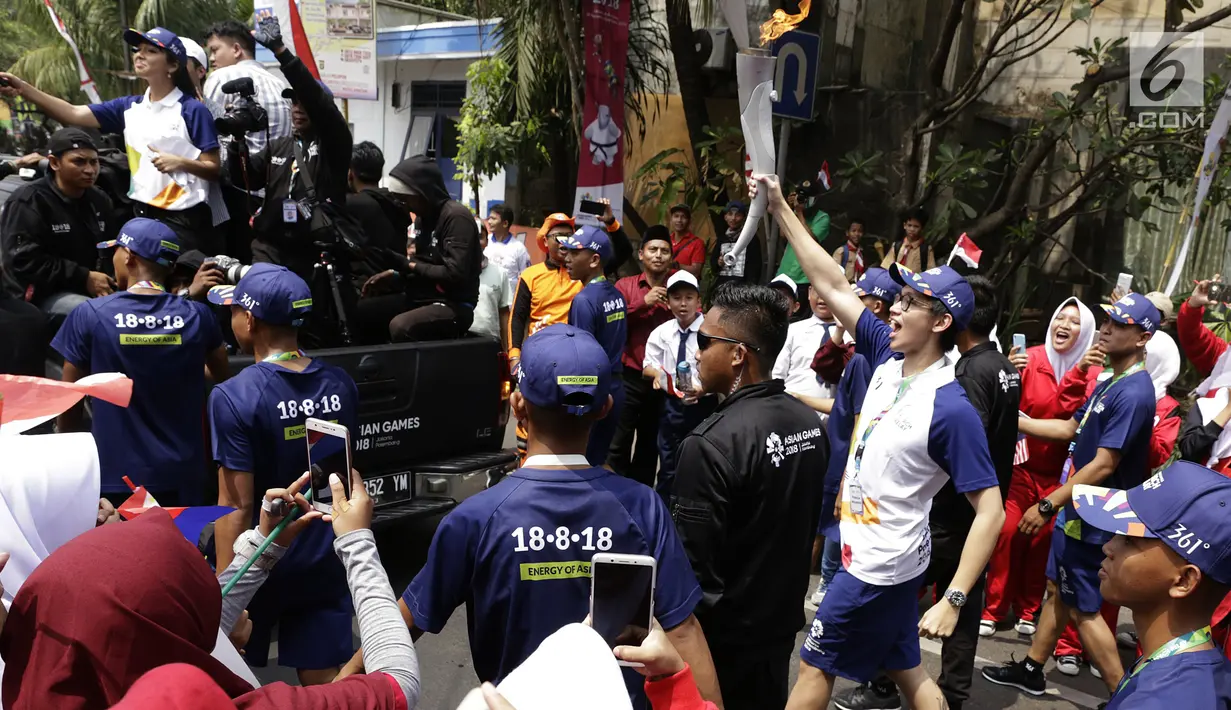 Aktor Brandon Salim membawa obor Asian Games saat Torch Relay Asian Games 2018 di Cipayung, Jakarta Timur, Rabu (15/8). Kirab obor Asian Games  di Jakarta berlangsung selama empat hari sebelum diinapkan di Istana Negara. (Kapanlagi.com/Agus Apriyanto)
