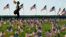 Aktivis dari COVID Memorial Project meletakkan ribuan bendera Amerika berukuran kecil di di halaman National Mall di Washington, Selasa (22/9/2020). Ribuan bendera itu menandai 200 ribu nyawa yang hilang akibat virus corona Covid-19 di Amerika Serikat. (AP Photo/J. Scott Applewhite)