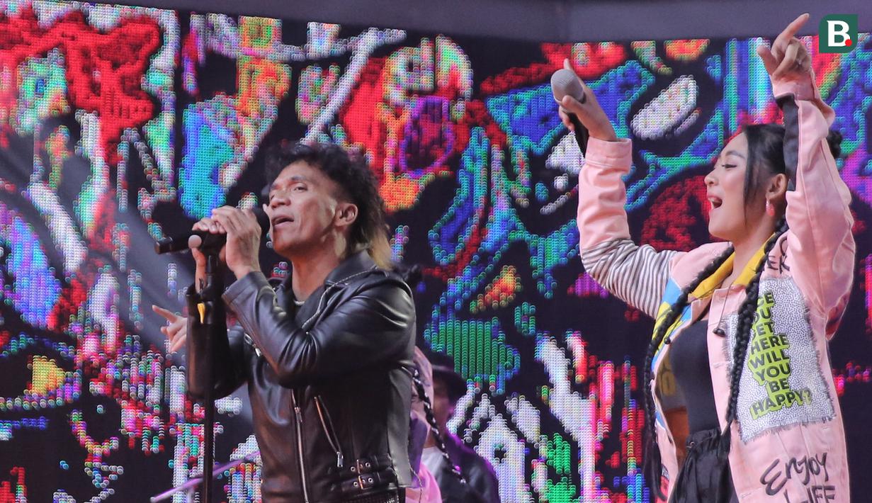 Vokalis band Slank, Kaka berduet dengan salah satu personel Duo Anggrek dalam konser Pesta Bola Dunia 2023 #Indonesia Sukses di Studio 5 Indosiar, Jakarta, Sabtu (4/11/2023) malam WIB. (Bola.com/Abdul Aziz)