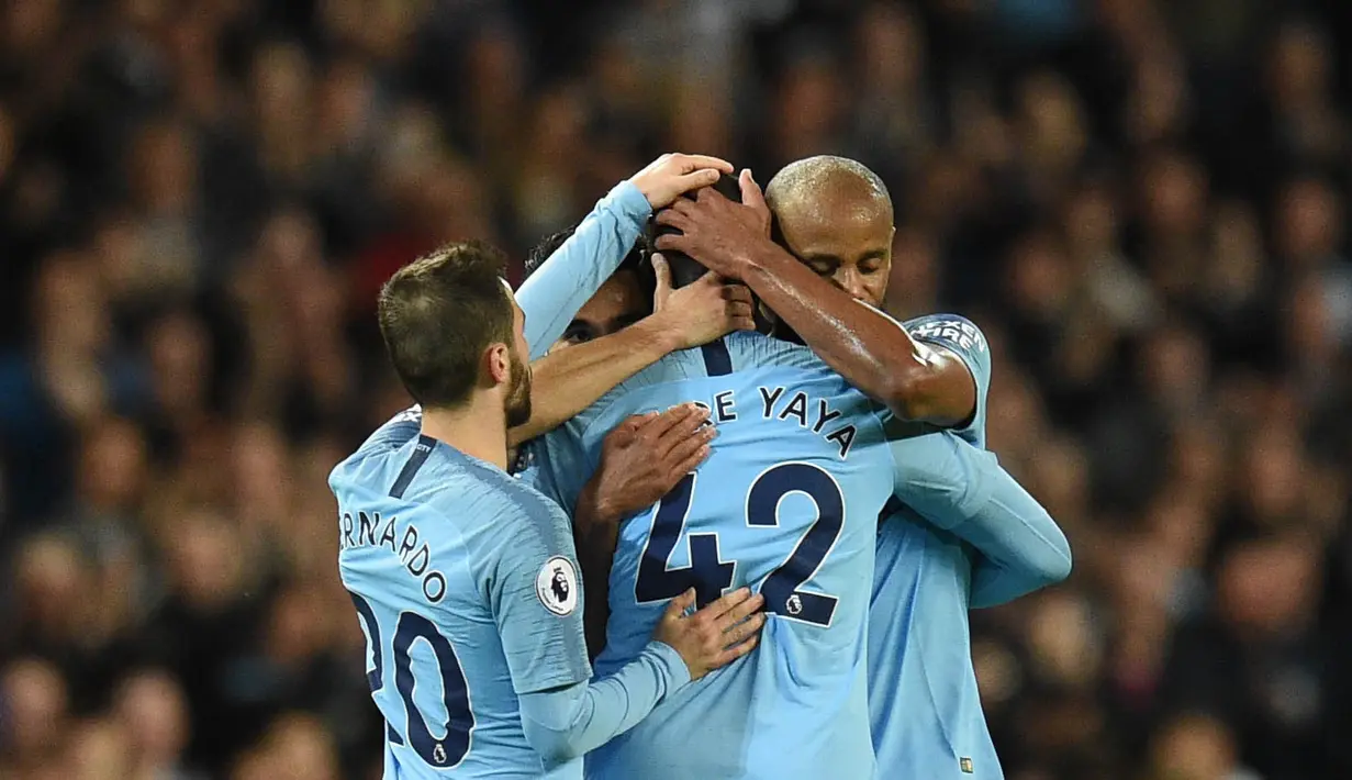 Para pemain Manchester City memeluk Yaya Toure usai laga melawan Brighton and Hove Albion di Stadion Etihad, Rabu (9/5/2018). Laga tersebut menjadi ajang perpisahan sang pemain bersama The Citizens. (AFP/Oli Scarff)