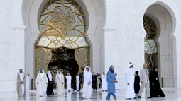 Pangeran Charles yang berpakaian formal, bersama Putri Camilla yang mengenakan pakaian seperti gamis panjang, lengkap dengan penutup rambut saat mengunjungi Masjid Syekh Zayed di Abu Dhabi, Uni Emirat Arab, Sabtu (5/11). (AFP/Karim Sahib)