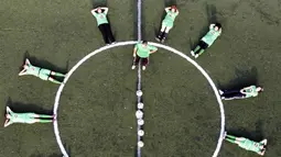 Pelatih pesepak bola putri klub Beit Umar Palestina, Mahmud Musleh, memberikan arahan kepada anak asuhnya saat sesi latihan di sebuah lapangan di Kota Hebron. (AFP/Hazem Bader)