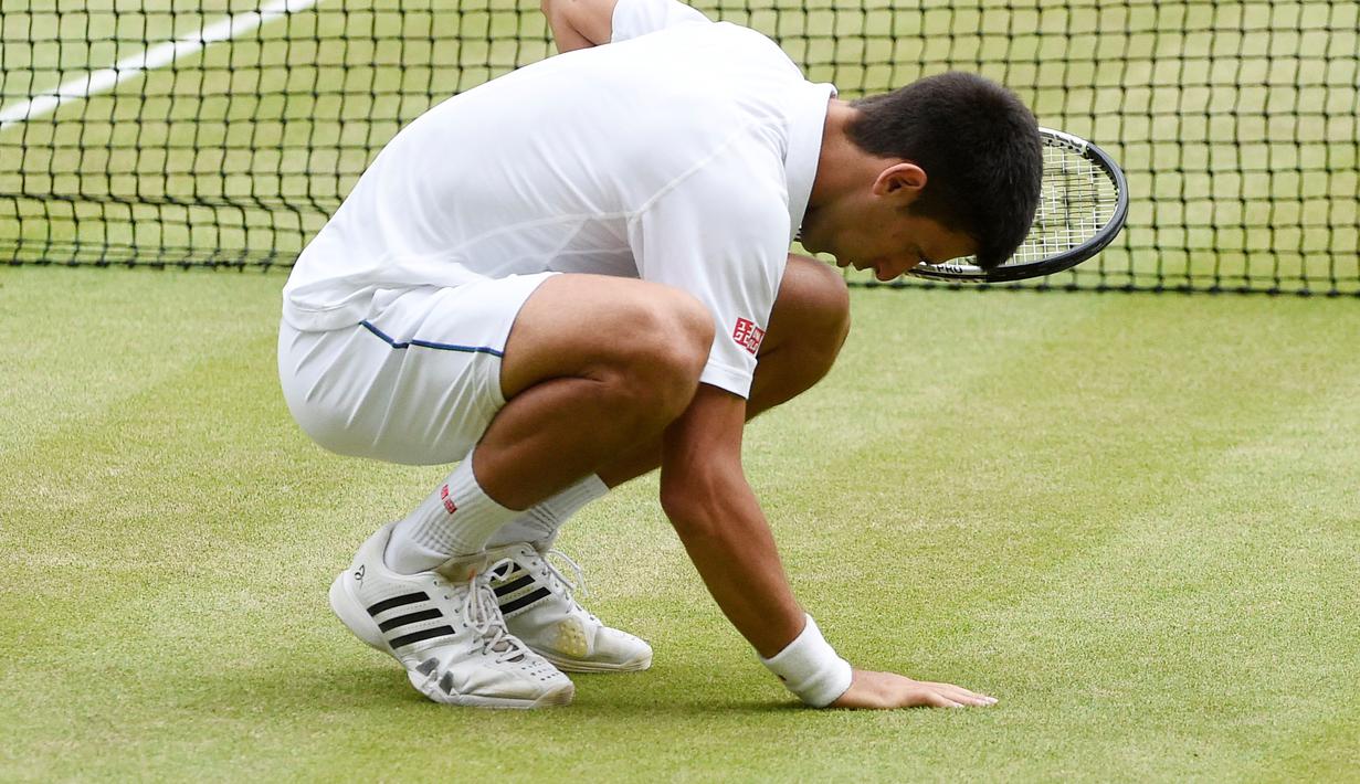 Novak Djokovic mengambil rumput lapangan dan memakannya menjadi ritual baginya bila meraih gelar Wimbledon. (EPA/FACUNDO ARRIZABALAGA)