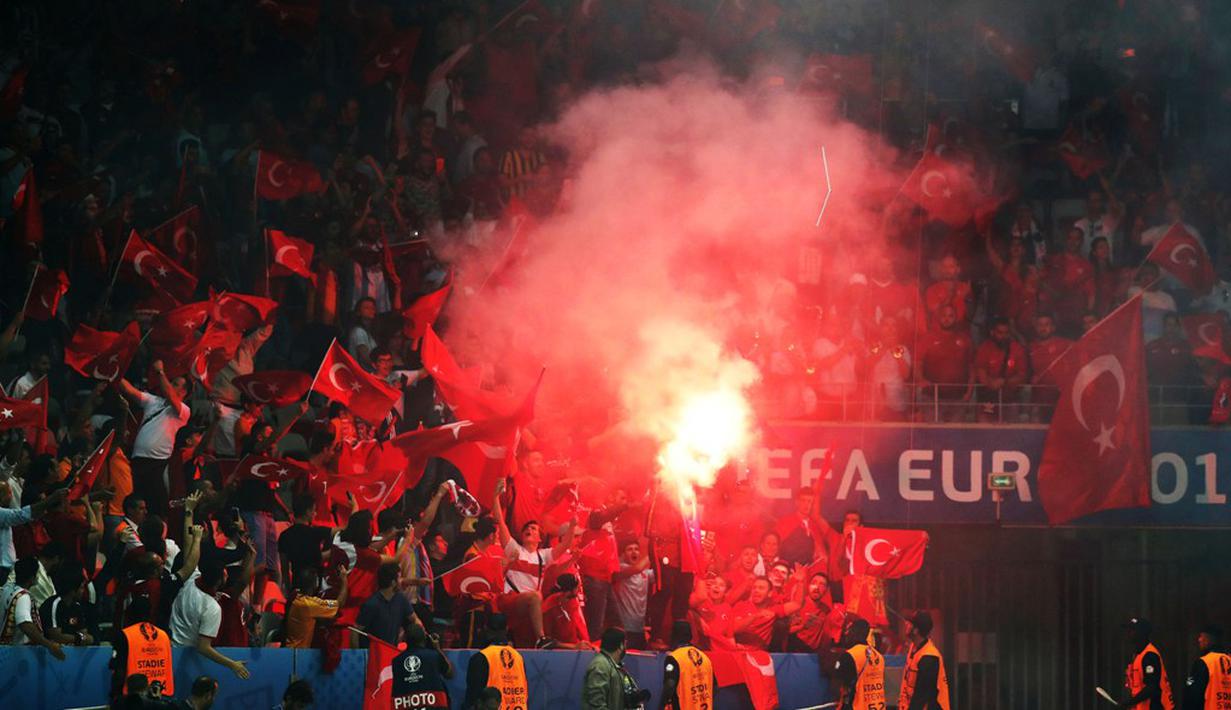 Suporter Turki menyalakan flare saat Spanyol melawan Turki pada laga Grup D Piala Eropa 2016 di Allianz Riviera, Nice, Sabtu (18/6/2016) dini hari WIB. (AFP/Valery Hache)