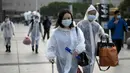 Warga mengenakan masker, sarung tangan, dan pakaian pelindung saat tiba di Stasiun Hankou, Wuhan, Hubei, China, Rabu (8/4/2020). Setelah pandemi virus corona COVID-19 mereda, banyak warga di Wuhan beraktivitas memakai masker, sarung tangan, pelindung wajah, hingga pakaian pelindung. (NOEL CELIS/AFP)