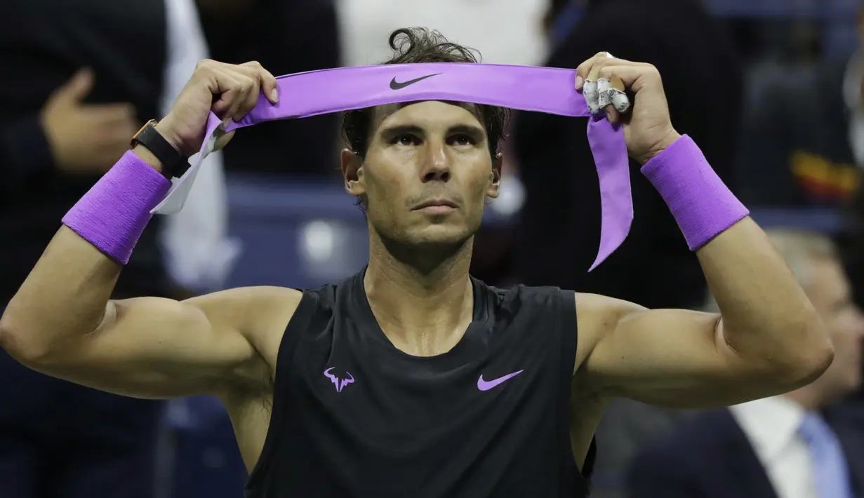 Petenis Spanyol, Rafael Nadal merapikan ikat kepalanya selama jeda saat bertanding melawan Matteo Berrettini dari Italia pada babak semifinal AS Terbuka 2019 di New York (6/9/2019). Nadal akan bertemu petenis Rusia, Daniil Medvedev.  (AP Photo/Adam Hunger)