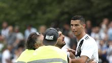 Seorang suporter berusaha memeluk penyerang Juventus, Cristiano Ronaldo selama pertandingan persahabatan antara Juventus A dan tim B, di Villar Perosa, Italia utara, (12/8). Pada pertandingan ini Ronaldo mencetak satu gol. (AFP Photo/Isabella Bonotto)