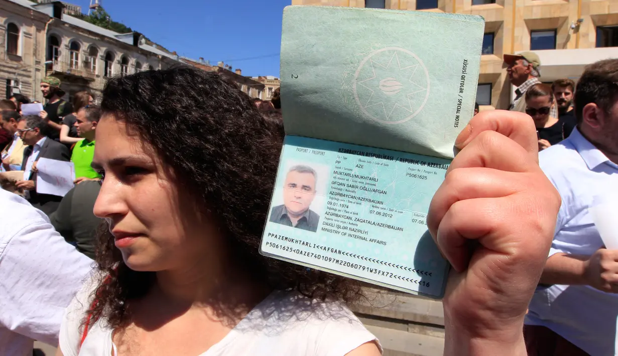 Istri Afgan Mukhtarli menunjukkan passport suaminya saat unjuk rasa di Tbilisi, Georgia, Rabu (31/5). Afgan Mukhtarli adalah wartawan Azerbaijan yang tinggal di Georgia, ia diculik dan disembunyikan di Azerbaijan.(AP Photo / Shakh Aivazov)