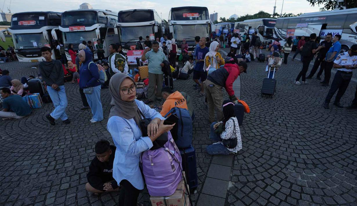 Pemerintah Provinsi DKI Jakarta memberangkatkan peserta mudik gratis 2026 dari Lapangan Monas pada Selasa 17 Maret 2026. Tampak dalam foto, orang-orang menunggu untuk menaiki bus yang akan mengangkut mereka ke kampung halaman untuk merayakan Hari Raya Idul Fitri 1447 Hijriah dalam perjalanan mudik gratis yang diselenggarakan oleh Pemerintah Provinsi Jakarta di Lapangan Monumen Nasional, Selasa 17 Maret 2026. (AP Photo/Achmad Ibrahim)