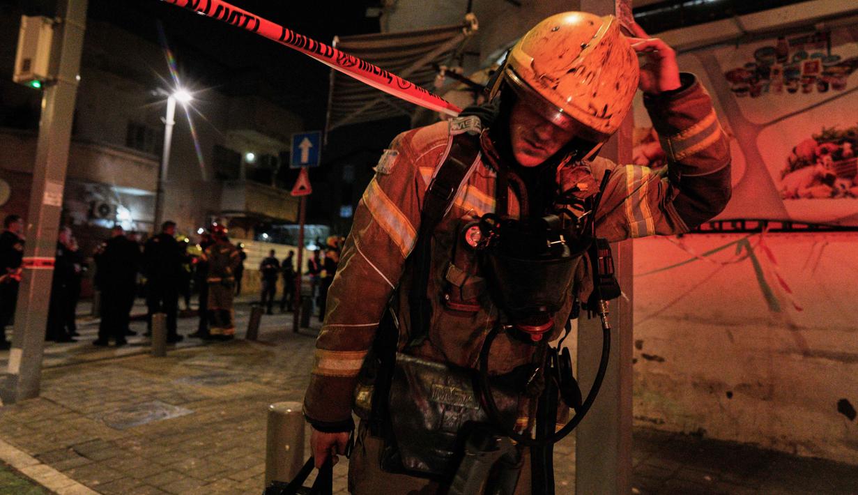 Seorang petugas tanggap darurat Israel berjalan di lokasi sekitar serangan rudal Iran di Tel Aviv, Israel, Sabtu 28 Maret 2026 pagi waktu setempat. Serangan rudal Iran kembali menghantam wilayah Tel Aviv, Israel, pada Sabtu 28 Maret 2026 pagi waktu setempat. (AP Photo/Maya Levin)