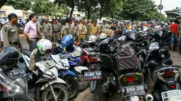 Petugas Kelurahan Senen bersama Dishub DKI dan Satpol PP menggelar razia parkir liar di wilayah Senen, Jakpus, Selasa (29/3/2016). Sejumlah kendaraan roda dua terjaring razia karena terparkir di bahu jalan ataupun trotoar. (Liputan6.com/Yoppy Renato)