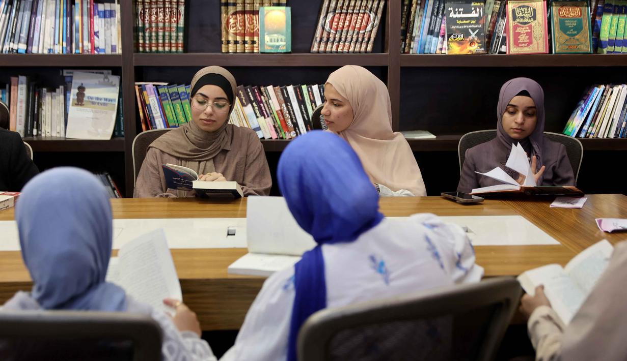 Sebagai informasi Perpustakaan ini didirikan oleh seorang penyair muda sekaligus apoteker Gaza, Omar Hamad. Tampak dalam foto, para pengungsi Palestina membaca buku di perpustakaan Al-Ankaa (Phoenix), perpustakaan pertama yang dibuka sejak gencatan senjata di Jalur Gaza yang berisi buku-buku yang diselamatkan dari perpustakaan yang hancur selama perang Israel-Hamas, di lingkungan Rimal, Kota Gaza pada Selasa 21 April 2026. (Omar AL-QATTAA/AFP)