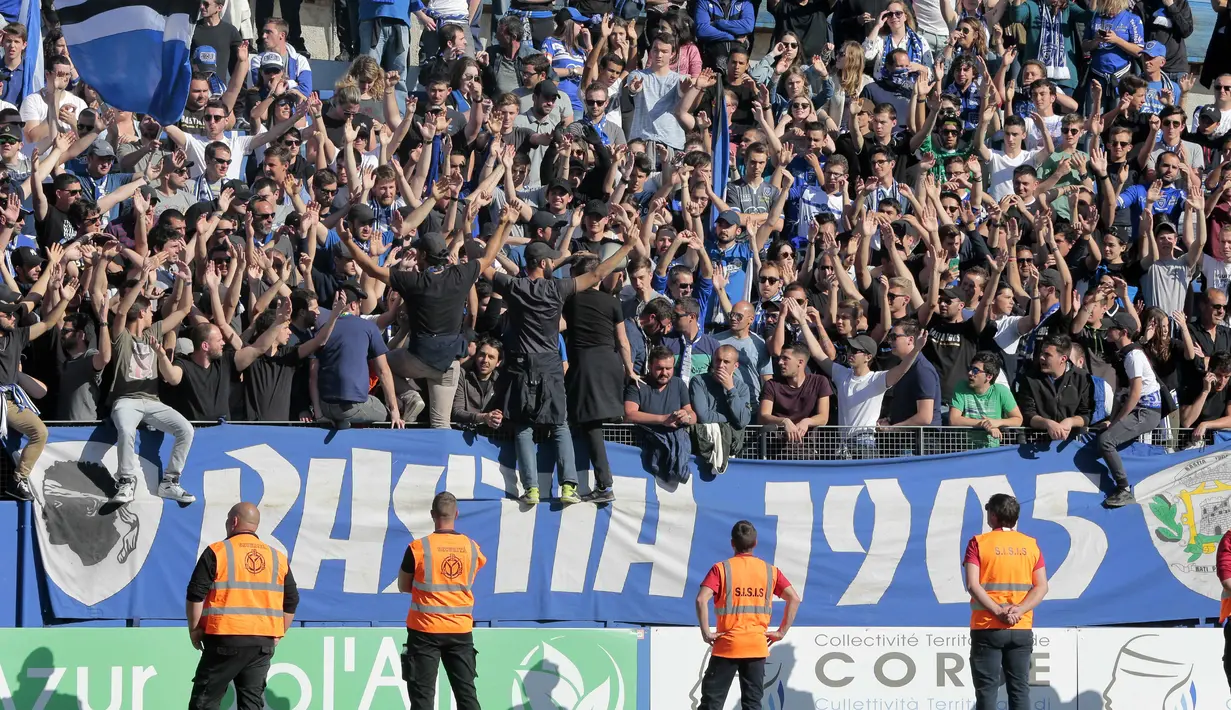 Aksi Suporter Bastia, Grup 1905 saat mendukung timnya berlaga melawan Lyon pada lanjutan Ligue 1 Prancis di Armand Cesari stadium, Bastia, (16/4/2017). Laga ini akhirnya dihentikan LFP. (AFP/Pascal Pochard-Casabianca)