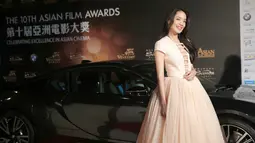Aktris asal Taiwan, Shu Qi tersenyum disamping mobil mewah saat menghadiri malam penganugerahan Asian Film Awards 2016 di Macau, China, Asian Film Awards diadakan setiap tahun sejak 2007. (AFP/ISAAC LAWRENCE)