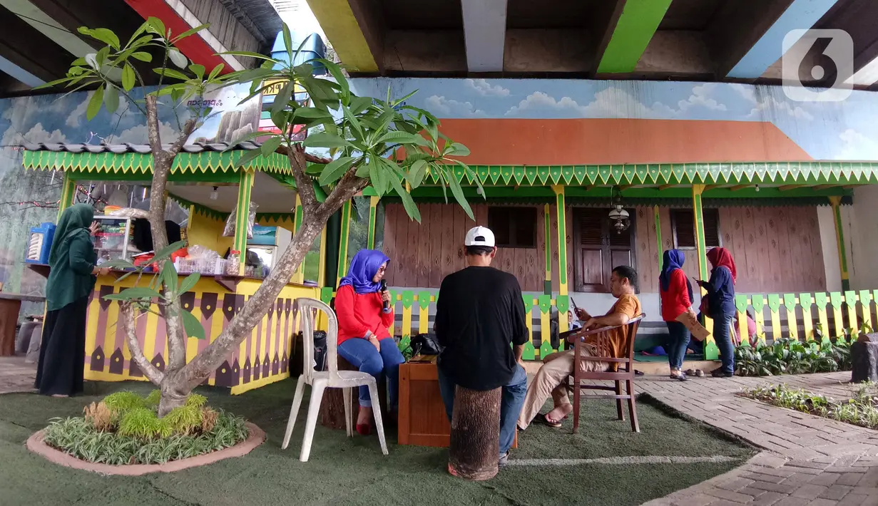 Warga beraktivitas di Taman Betawi Bale Joglo yang terletak di kolong tol JORR W2, Joglo, Jakarta, Senin (13/1/2020). Bale joglo adalah kantin di bawah kolong tol Joglo yang dimanfaatkan sebagai tempat untuk berjualan makanan khas Betawi. (Liputan6.com/Angga Yuniar)