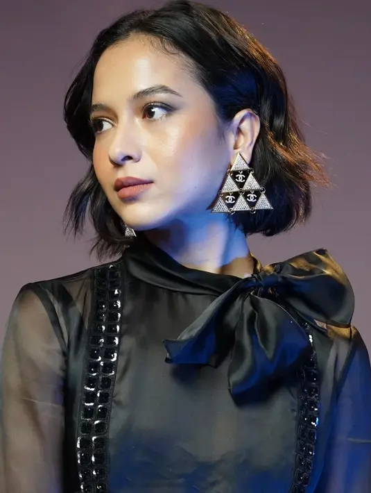 Putri Marino jadi Human Chanel seutuhnya dengan booth heels putih, handbag hitam, dan anting segitiga [@putrimarino]