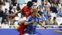 Gelandang Vietnam, Khuat Van Khang dan gelandang Jepang, Ritsu Doan melompat untuk menyundul bola dalam laga Grup D Piala Asia 2023 Qatar di Stadion Al-Thumama, Doha, Qatar, Minggu (14/1/2023). (AFP/Karim Jaafar)