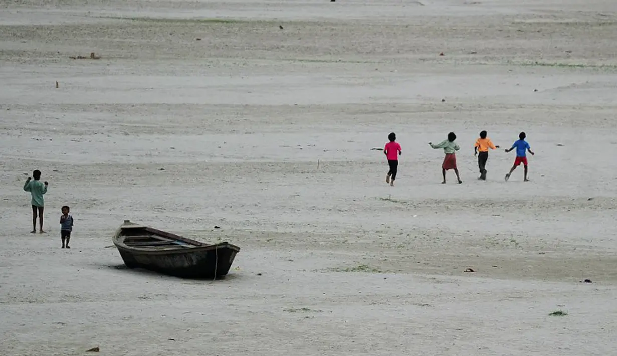 Sejumlah anak berlarian mengejar layang-layang di sebuah sungai yang kering di Allahabad, India (3/6/2015). Cuaca panas yang melanda India tidak hanya menewaskan ratusan warga, tetapi mengubah sungai menjadi seperti lapangan.  (AFP PHOTO/SANJAY Kanojia) 