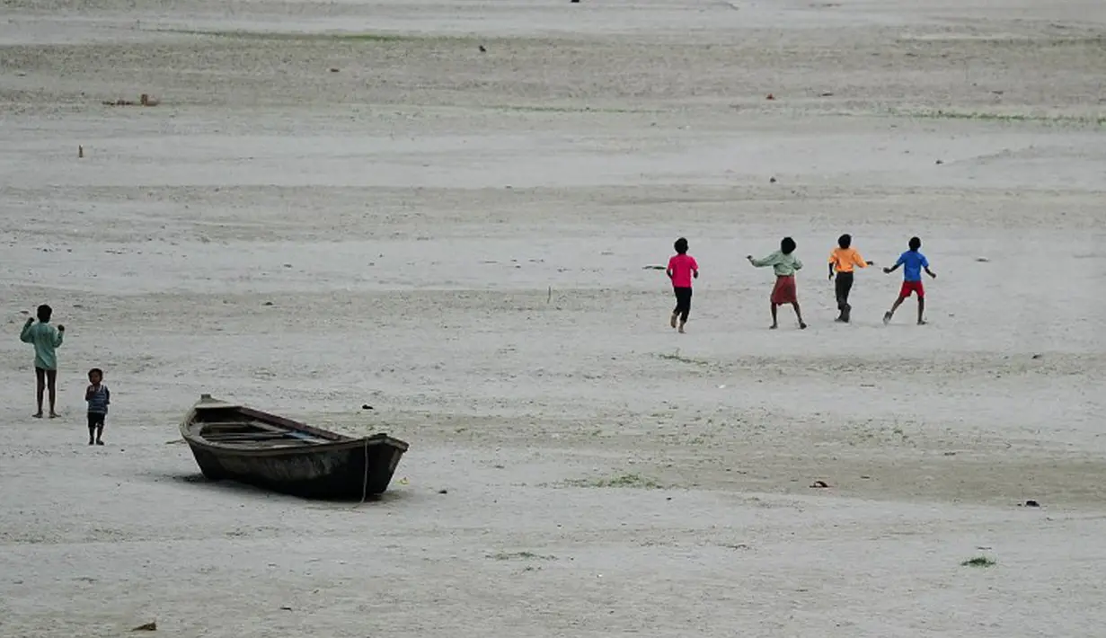 Sejumlah anak berlarian mengejar layang-layang di sebuah sungai yang kering di Allahabad, India (3/6/2015). Cuaca panas yang melanda India tidak hanya menewaskan ratusan warga, tetapi mengubah sungai menjadi seperti lapangan.  (AFP PHOTO/SANJAY Kanojia) 