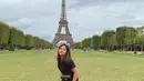Amel Carla juga terlihat berpose dengan pakaian serba hitam dengan latar belakang menara Eiffel. (Liputan6.com/IG/@amelcarla)