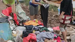 Warga memilah sampah sisa banjir yang menumpuk di kawasan Cipinang Melayu, Jakarta, Rabu (8/1/2020). Banjir yang melanda Jakarta dan sekitarnya sejak 1 Januari 2020 lalu menyisakan tumpukan sampah di sejumlah titik. (Liputan6.com/Herman Zakharia)