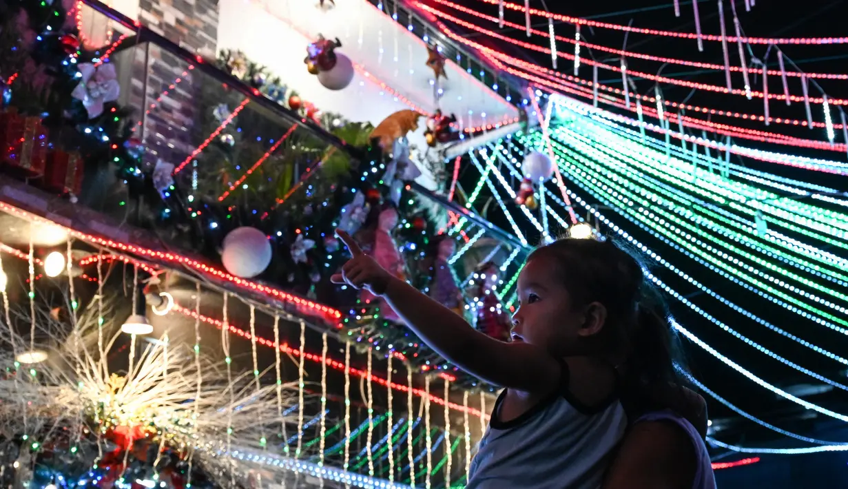 Seorang anak melihat sebuah rumah bertema Natal di Manila, Filipina (21/12/2022). Perayaan Natal tinggal menghitung hari, warga Manila antusias mengunjungi rumah yang didekor dengan ornamen dan hiasan Natal itu. (AFP/Jam Sta Rosa)