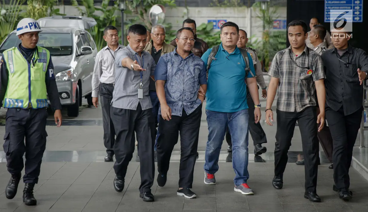 Anggota DPRD Provinsi Jambi Supriyono (depan), PLT Dinas PUPR Jambi Arfan (belakang) dikawal petugas memasuki Gedung KPK, Jakarta, Rabu (29/11). OTT tersebut terkait kasus dugaan suap APBD Jambi tahun 2018. (Liputan6.com/Faizal Fanani)